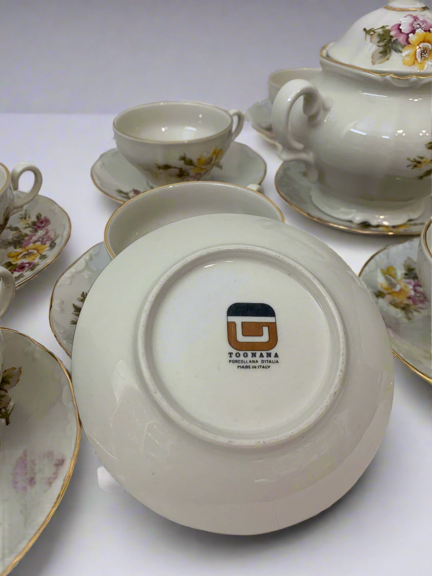 Vintage 1970s Italian porcelain tea set by Tognana with hand-painted floral pattern, 11 cups, 12 saucers, and a sugar bowl with gold trim.