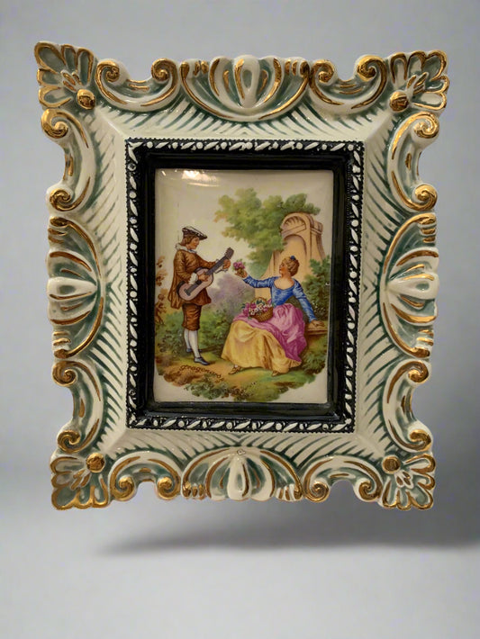 Vintage porcelain wall plaque with ornate ceramic frame and hand-painted lady and minstrel scene by Fratelli Rossi, Italy, 1950s/60s, 22.5x19cm.