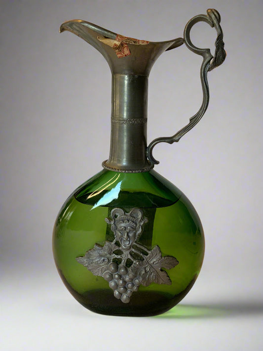 Vintage Tokai grappa bottle by I.L.L.V.A. with green glass, pewter neck, spout, and grapevine detail. Original label and seal intact – 1960s/70s.