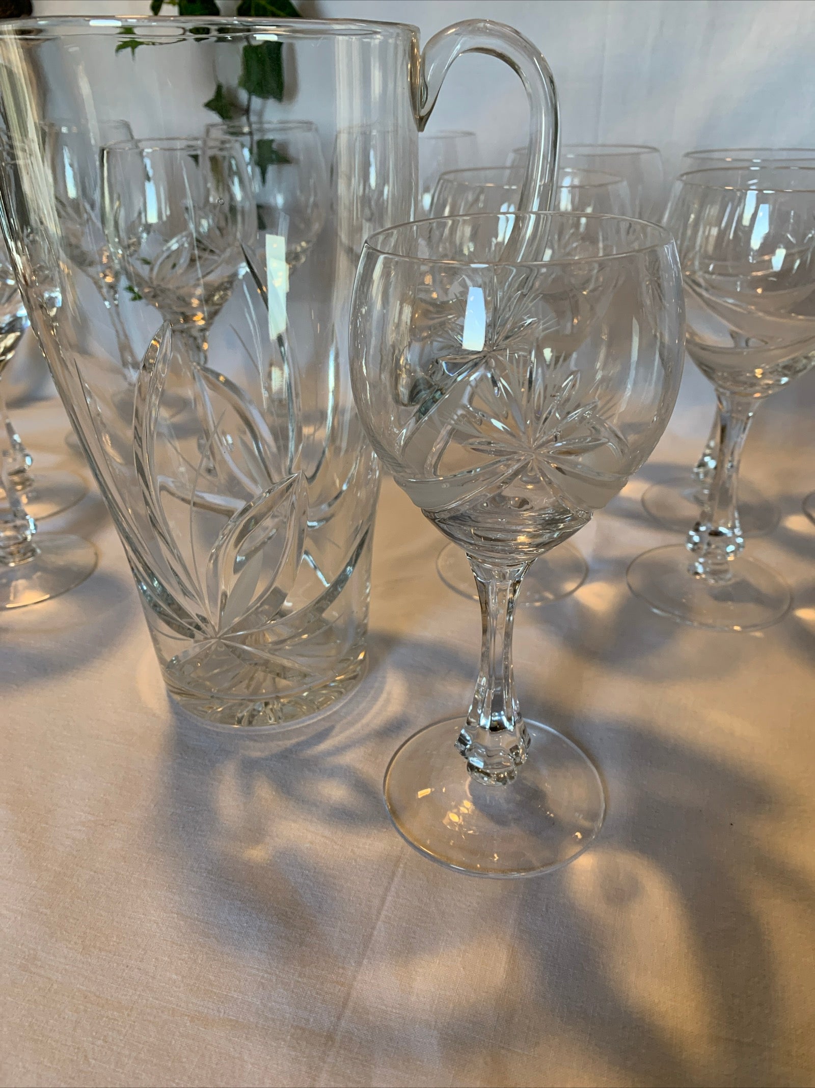 Vintage crystal table set with 6 wine goblets, 6 water goblets, and matching pitcher featuring raised floral pattern – clear glass in perfect condition.
